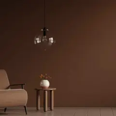 Ein Sessel in warmem Braun steht neben einem kleinen Beistelltisch mit einer Vase. Die Wand und der Boden sind in verschiedenen Brauntönen gehalten, die sich harmonisch mischen.