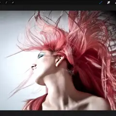 Ein Porträt einer Frau mit leuchtend rotem Haar, das im Wind weht. Dieses Bild wurde mit Procreate erstellt, einer digitalen Zeichen-App.