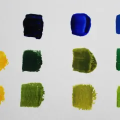 Farbproben auf weißem Papier: Blau, Dunkelblau, Gelb und verschiedene Grüntöne, die zeigen, wie man grün mischen kann.