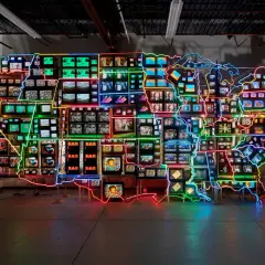 Eine Landkarte der USA aus vielen kleinen Bildschirmen, umrandet von bunten Neonlichtern. Ein Kunstwerk, das den **fluxus** der Informationen und Bilder widerspiegelt.