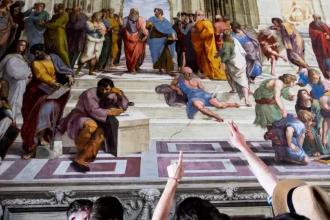 Die Schule von Athen: Bildanalyse zeigt Philosophen im Dialog. Eine Gruppe von Menschen betrachtet das Meisterwerk.