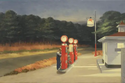 Edward Hopper, ein berühmter Maler, zeigt eine einsame Tankstelle mit roten Zapfsäulen und einem Mann, der tankt.