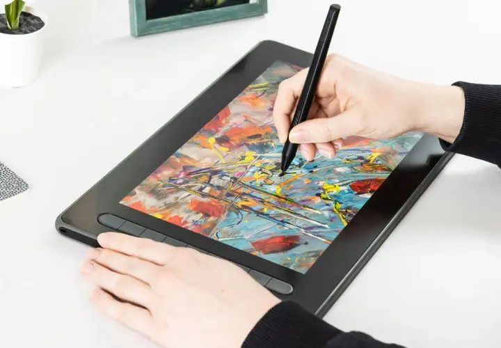 Hand zeichnet mit Stift auf einem Grafiktablett mit bunter Malerei.