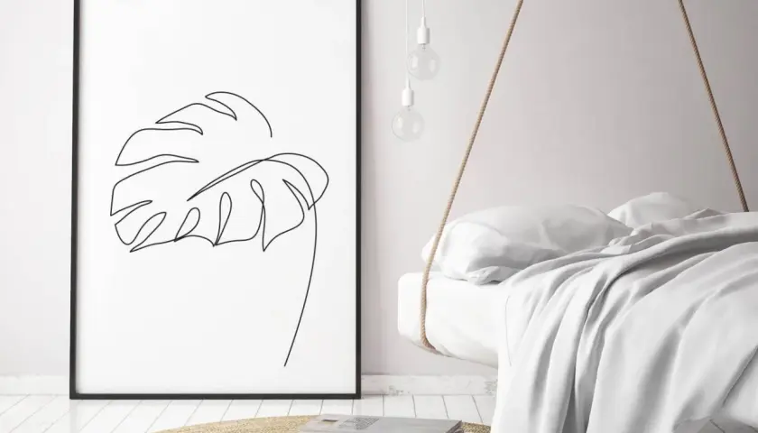 Gerahmtes Blatt-Linienkunst-Bild neben einem schwebenden Bett.