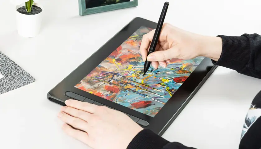 Hand zeichnet mit Stift auf einem Grafiktablett mit bunter Malerei.