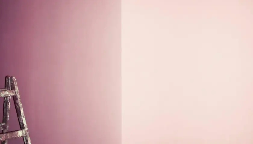 Eine Leiter steht vor einer Wand, die in sanften Tönen von pink und lila mischen übergeht.