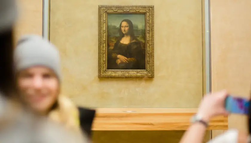 Das berühmte Gemälde der Mona Lisa, das Leonardo da Vinci gemalt hat, wird von Besuchern im Louvre fotografiert.