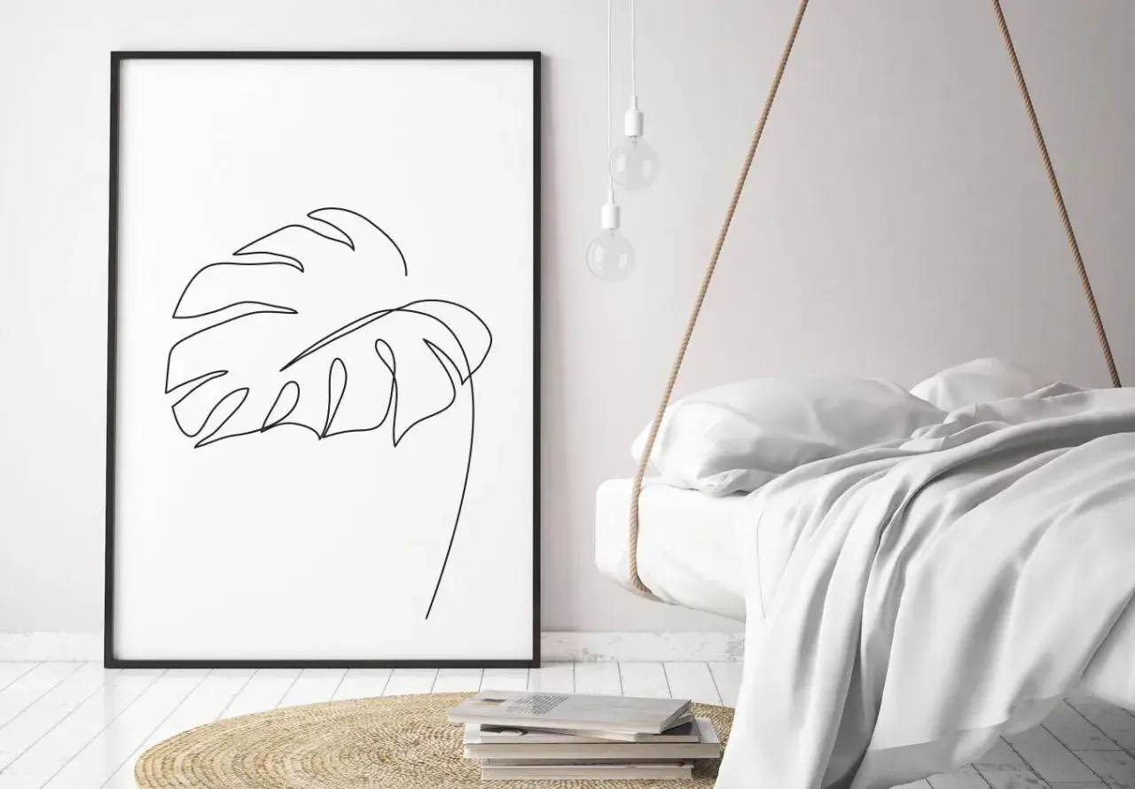 Gerahmtes Blatt-Linienkunst-Bild neben einem schwebenden Bett.