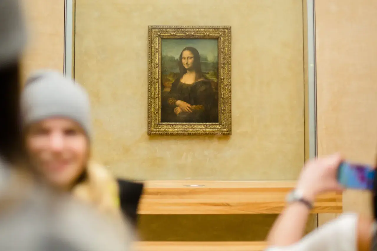 Das berühmte Gemälde der Mona Lisa, das Leonardo da Vinci gemalt hat, wird von Besuchern im Louvre fotografiert.