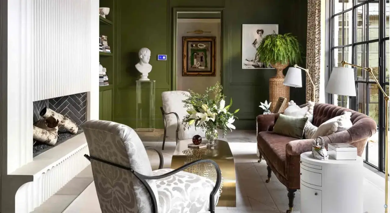 Ein grünes Wohnzimmer mit einem braunen Sofa und gemusterten Sesseln. Welche Farbe passt zu Grün? Hier: Braun und Weiß harmonieren perfekt.