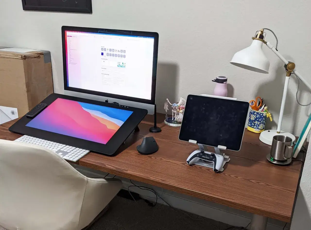 Kreativer Arbeitsplatz mit iMac, Grafiktablett und iPad für Procreate. Ein Controller liegt bereit.