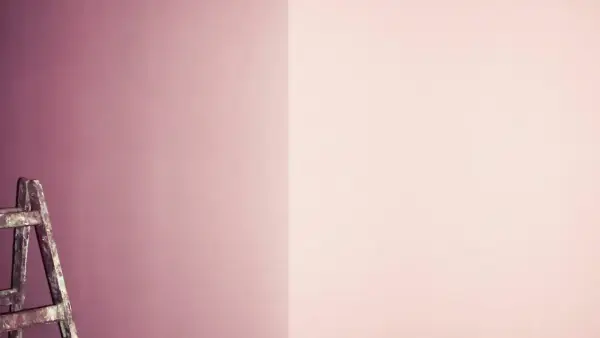 Eine Leiter steht vor einer Wand, die in sanften Tönen von pink und lila mischen übergeht.